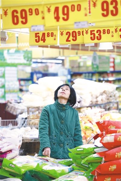 2014年1月9日,江西九江,消费者在一家超市查看大米价格牌。 图/CFP 2014年1月9日,江西九江,消费者在一家超市查看大米价格牌。 图/CFP